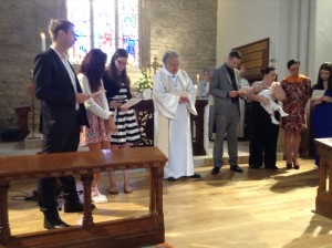 Elijah's parents and godparents make their promises at Elijah's baptism