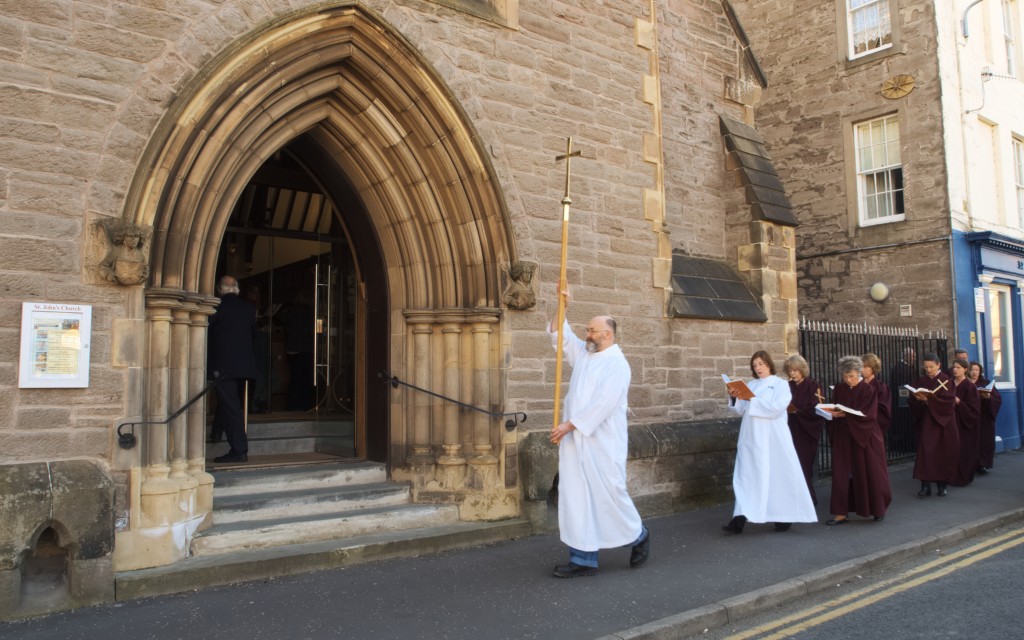 David leads a procession of the choir and congregation along the street at the start of the service