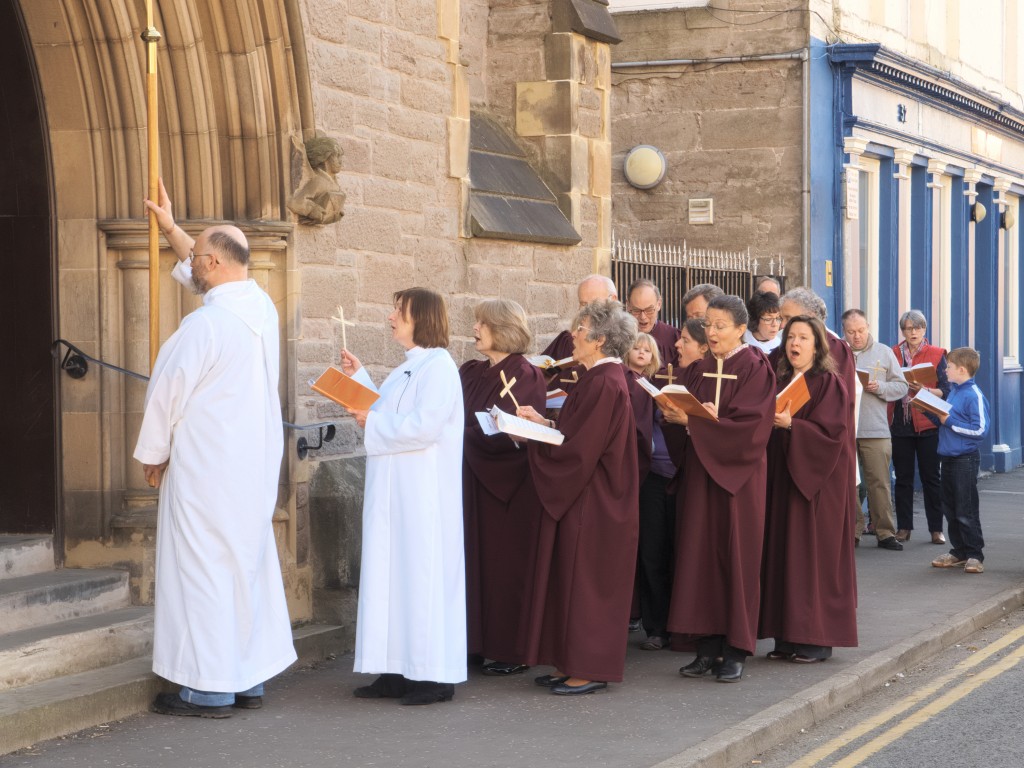 David leads a procession of the choir and congregation along the street at the start of the service