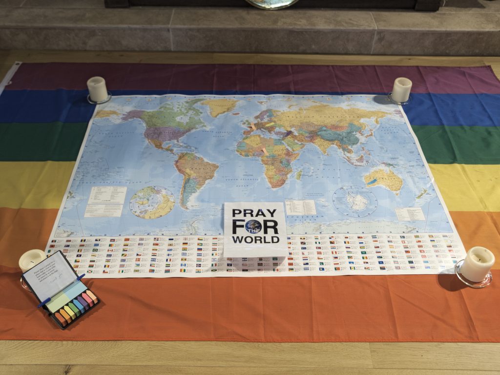 A world map laid out in front of the altar for folks to pin prayers on countries and areas.