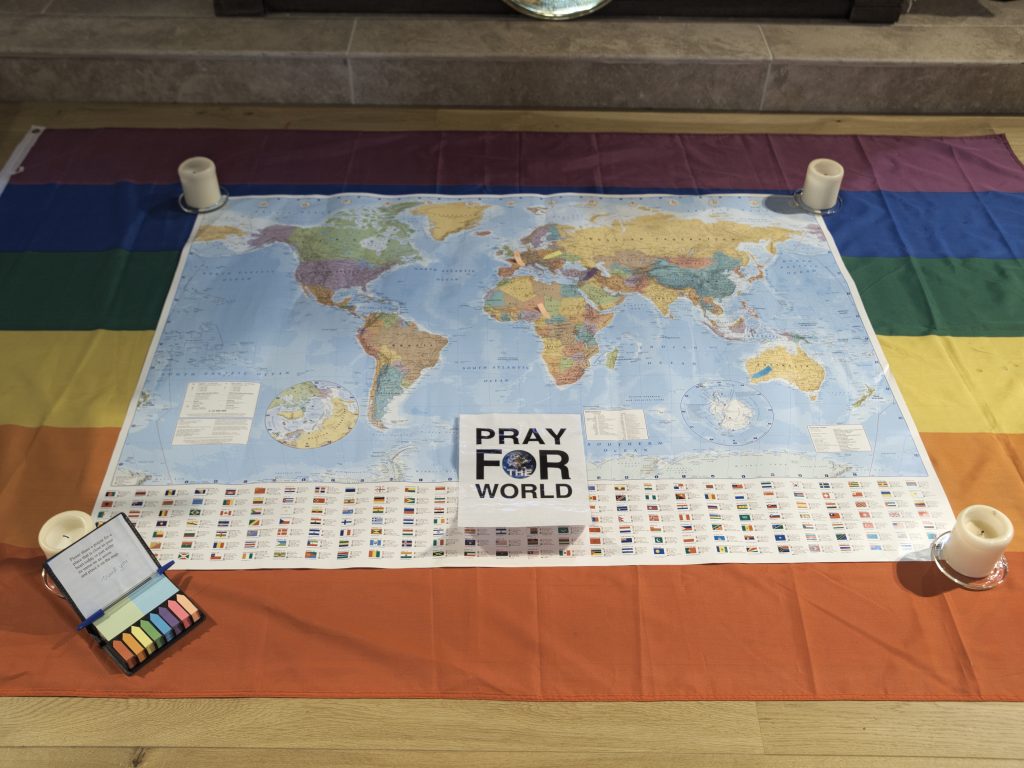 A world map laid out in front of the altar for folks to pin prayers on countries and areas.